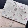 tekstkaart gefeliciteerd: gestempeld op handgeschept papier met bloemblaadjes
